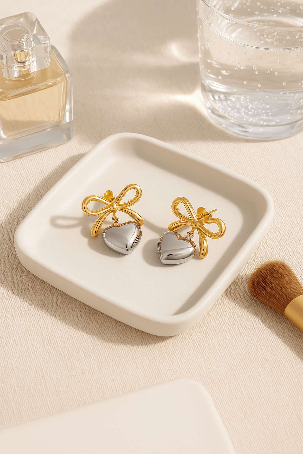 MEA NANI JEWELLERY Øredobber AMOUR BOW EARRINGS – 18K gullbelagte hjerteøredobber i kirurgisk stål