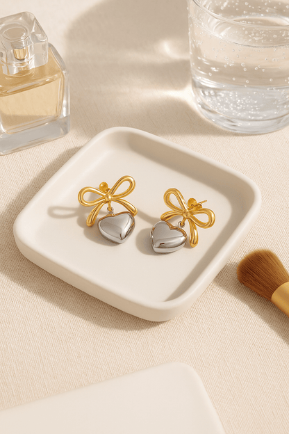MEA NANI JEWELLERY Øredobber AMOUR BOW EARRINGS – 18K gullbelagte hjerteøredobber i kirurgisk stål